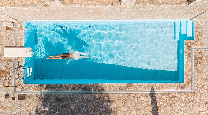 A birds view of a yard with a plunge pool and person swimming