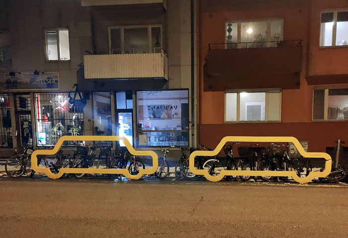 These "Cars" Showcasing The Amount Of Bikes You Can Fit In Two Parking Spots, Whilst Also Protecting The Bikes From The Traffic