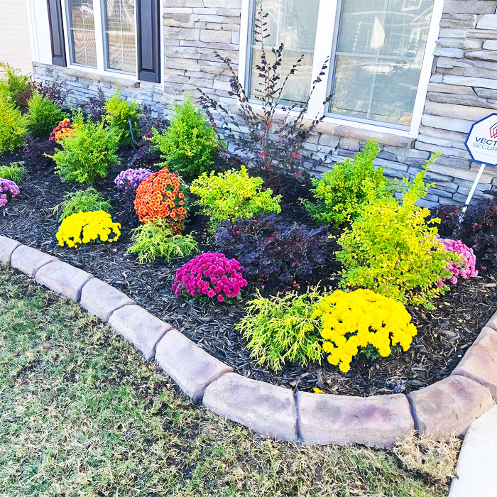 Picture of concrete flower bed edging with colorful flowers