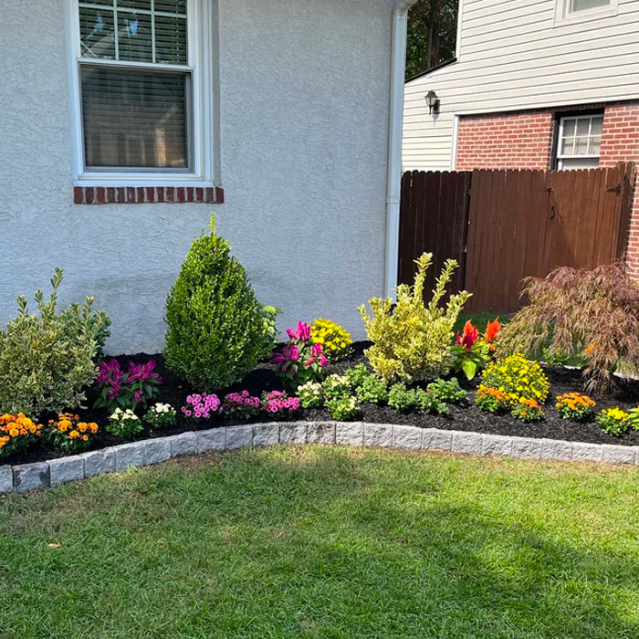 Picture of cobblestone flower bed edging with colorful flowers