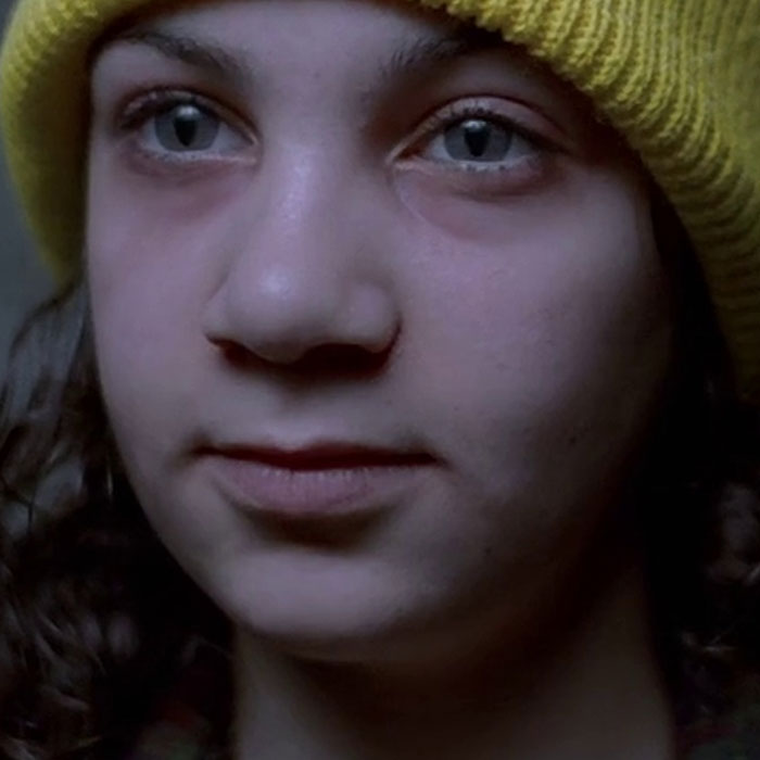 Woman wearing yellow hat in Let the Right One In 