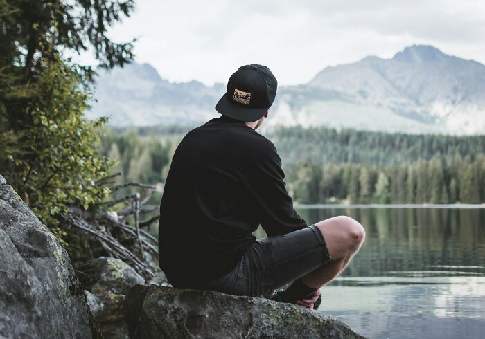 Person sitting and looking at mountains