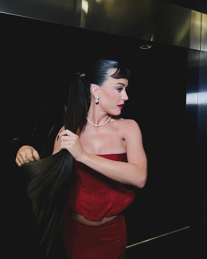Singer Katy Perry in a red outfit, showcasing tattoo and style at a music awards event. Singer Katy Perry in a red outfit, showcasing tattoo and style at a music awards event.