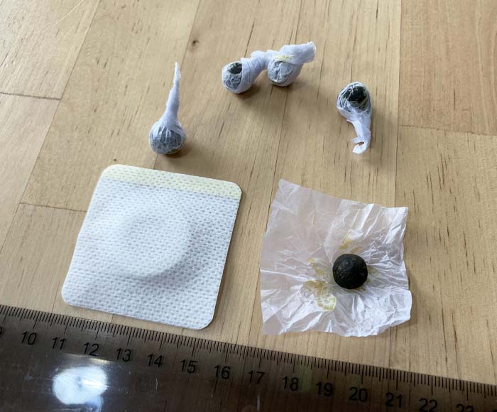 This Came In The Mail. 5 Self-Adhesive Rubber O Shapes And 5 Screws Of Paper With A Hard, Dark Green Ball Of Something Oily. What Are These Creepy Things?