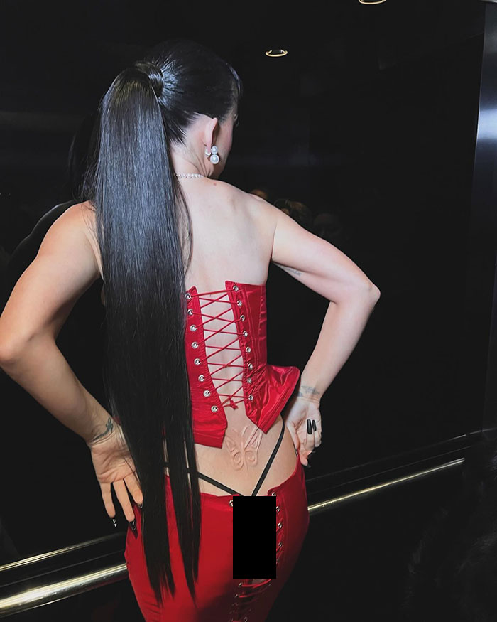 Katy Perry in red lace-up outfit showing tattoo and thong. Katy Perry in red lace-up outfit showing tattoo and thong.