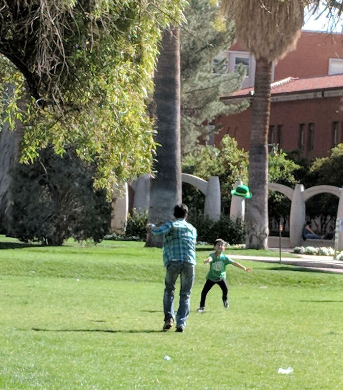 A Dad Playing Catch With His Son Using A Leprechaun Hat On St. Patrick's Day