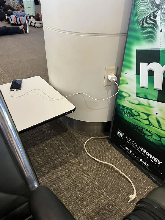 Una persona en el aeropuerto ha desenchufado el cajero automático para cargar su teléfono