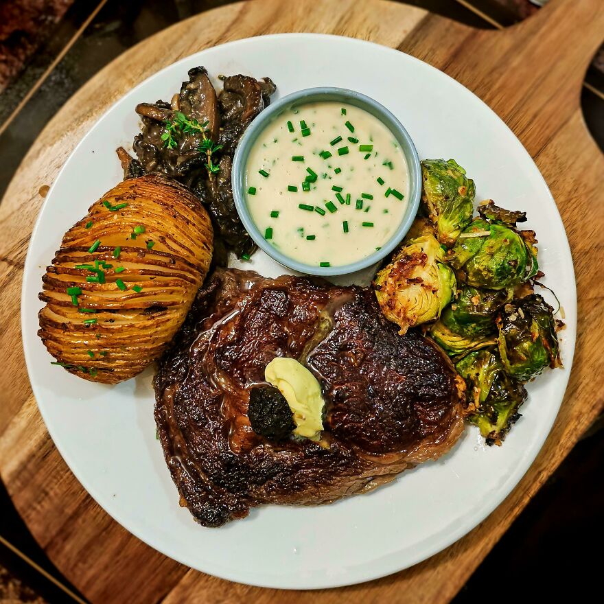 Rib-Eye Cooked Medium Rare, Bone-Marrow Hasselback Potatoes, Air Fried Garlic Parmesan Brussel Sprouts, Thyme And Sage Mushrooms, And Blue-Cheese Sauce