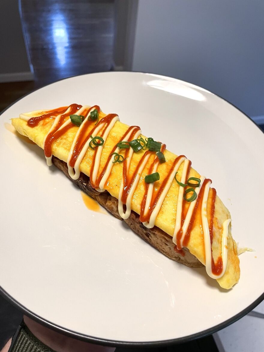 A Cheesy Omelette On Toasted Sourdough, Topped With Mayo, Sriracha, Chili Oil, And Green Onions