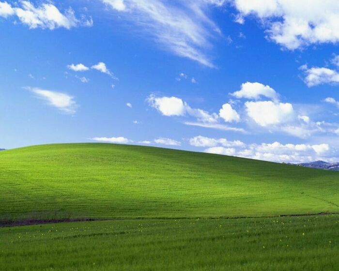 Fondo de pantalla de Microsoft Xp 'Bliss' de Charles O'rear: una fotografía prácticamente sin editar de una colina verde y un cielo azul con nubes en el condado de Sonoma, 1996