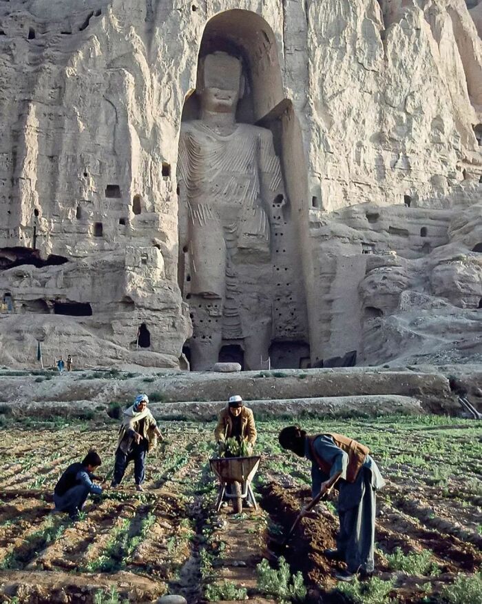 Trabajadores agrícolas frente al Gran Buda del valle de Bamiyán en Afganistán, fotografiado por Steve McCurry, 1992. La estatua fue destruida por los talibanes en 2001