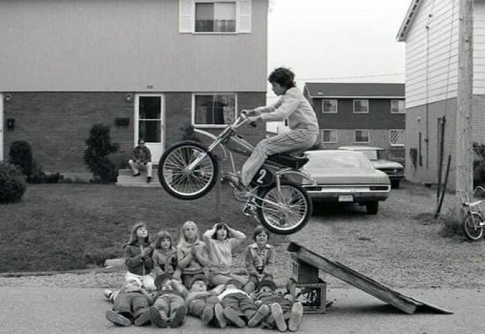 Bici equipada, chicas mirando, supervisión de adulto, todo correcto