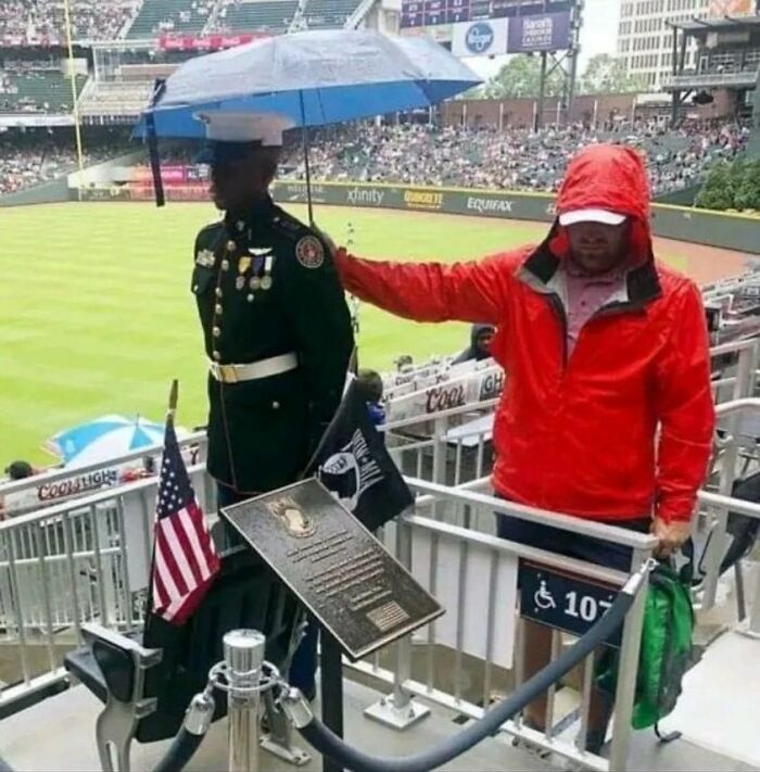 This Guy Holding An Umbrella Over A Soldier Standing By The Seat And Plaque Dedicated To The 92,000+ Unaccounted For American Soldiers Since Wwi