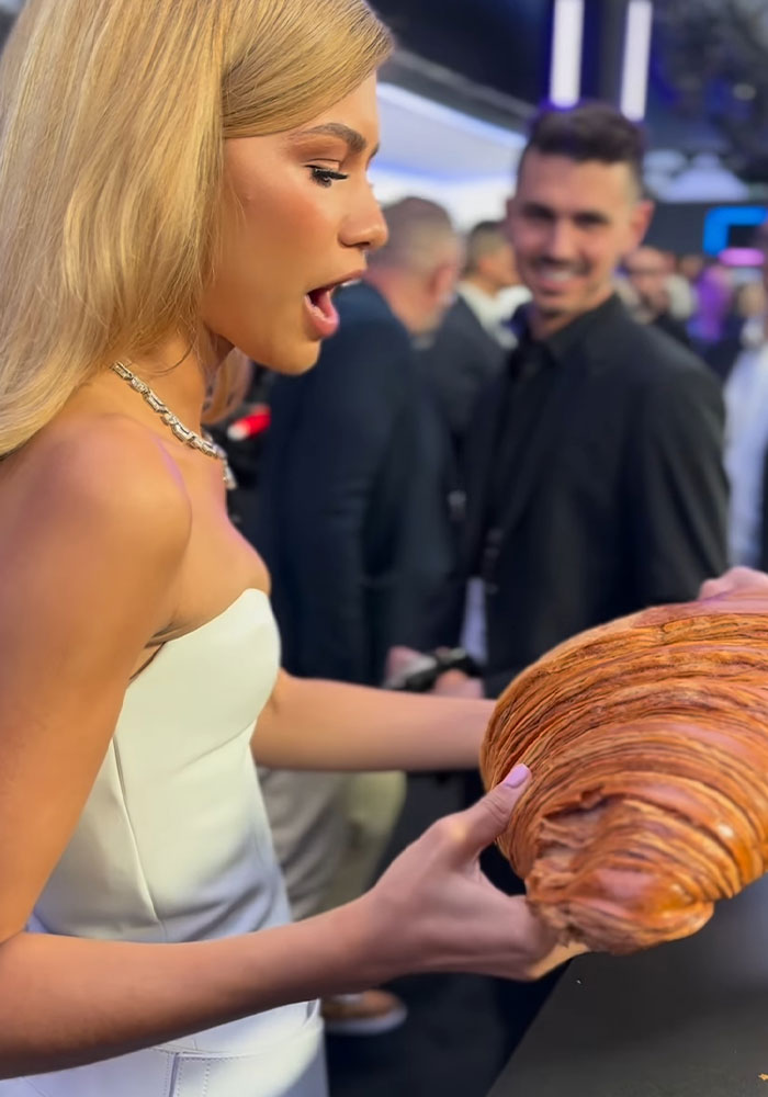 Zendaya Effortlessly Poses With The Giant Croissant She Received As A Gift At Paris Premiere
