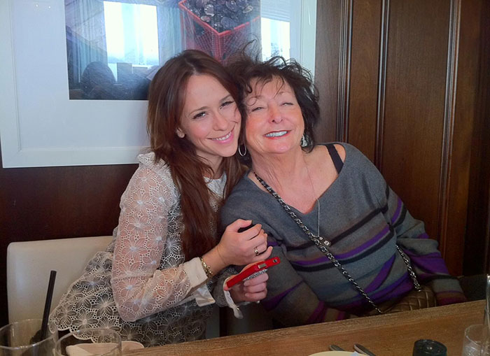 Jennifer Love Hewitt smiling and embracing an older woman, sharing a warm moment indoors at a restaurant. Jennifer Love Hewitt smiling and embracing an older woman, sharing a warm moment indoors at a restaurant.