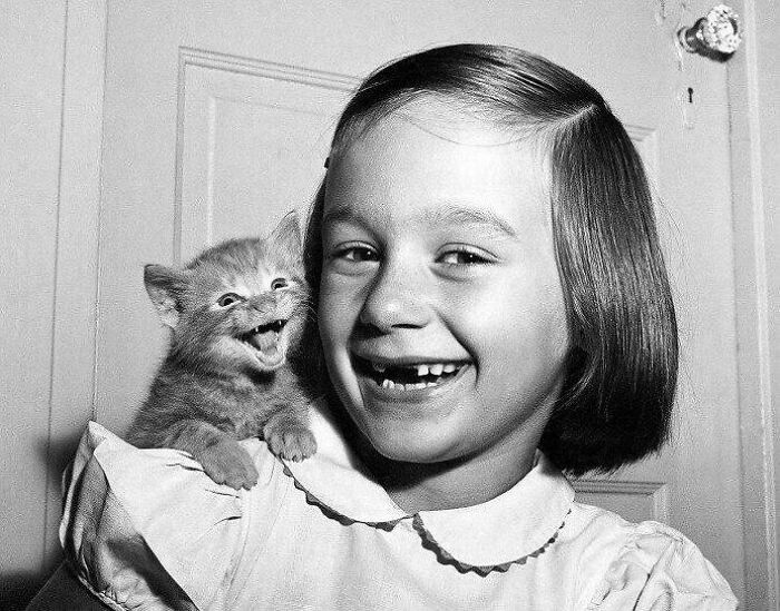 El fotógrafo Walter Chandoha retrató a su hija Paula y su gatito sonriendo a la cámara a la vez, 1955