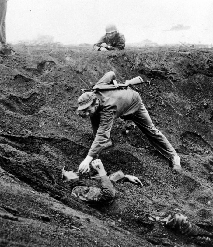 A Us Marine Gives A Cigarette To A Japanese Soldier Buried In The Sand. Iwo Jima, 1945