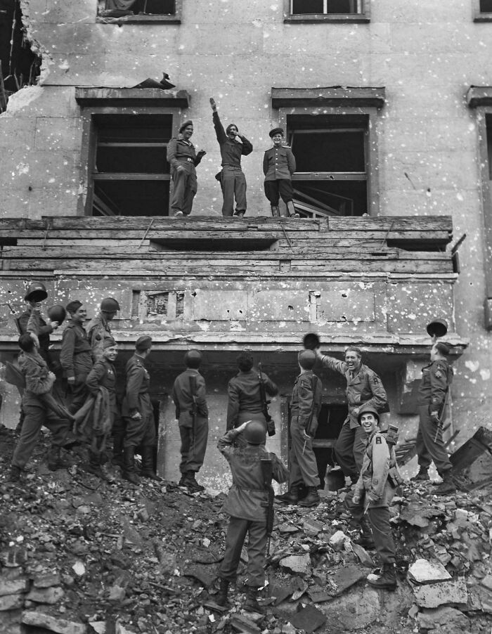 Soldados aliados burlándose de Hitler en su balcón de la Cancillería, 1945