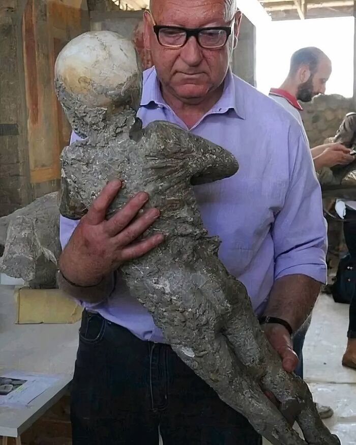 An Archaeologist Holds A Plaster Cast Of A Child’s Body That Died As A Result Of The Eruption Of Vesuvius In 79 Ce In Pompeii