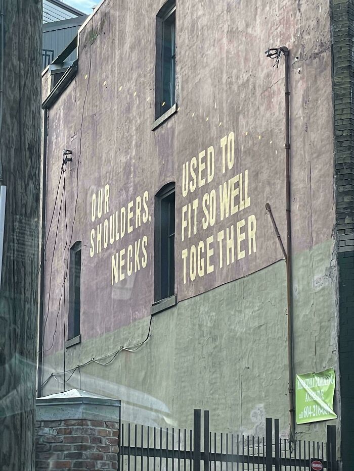 Sign fail on a building wall with text misaligned, creating an unintended message.