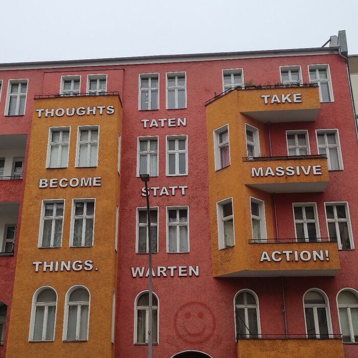 Colorful building with sign fail featuring mixed language messages about thoughts and action.