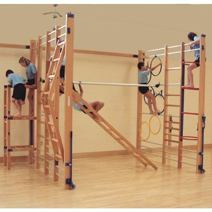 Children on a typical British school gym set, climbing and playing during a PE class.