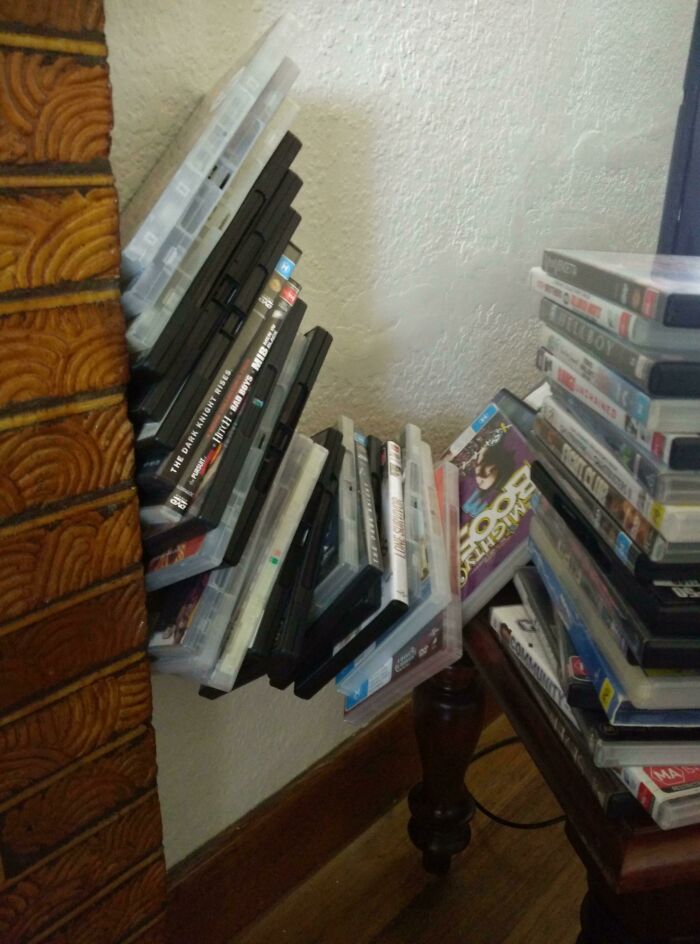 Stack of DVDs and cases arranged in a gravity-defying way, showcasing a wild coincidence captured in a photo.