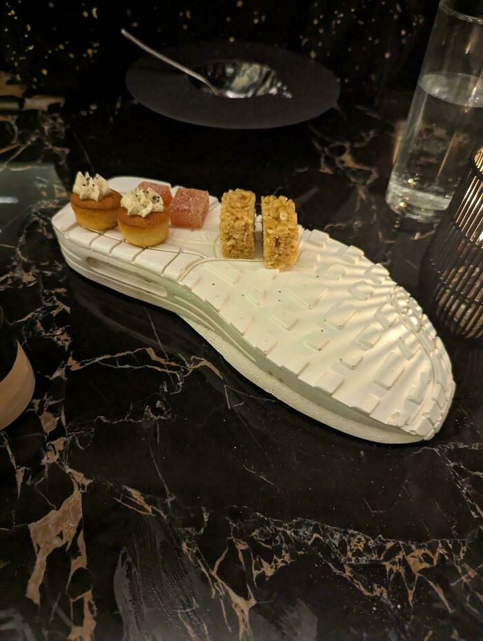 Small desserts served on a white shoe sole plate illustrating one of the most ridiculous ways food is served in restaurants.
