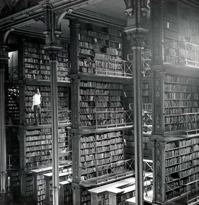 Hombre buscando libros en la antigua biblioteca de Cincinnati, demolida en 1955