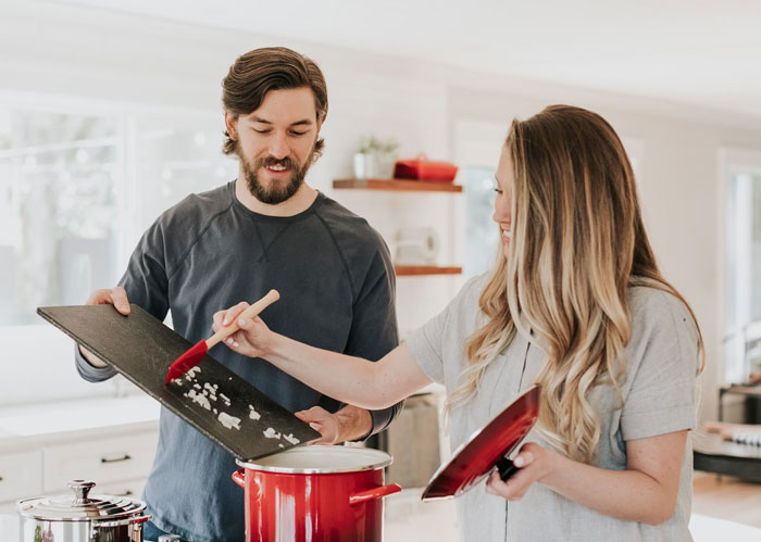 Husband attempts a cooking surprise for wife on Mother's Day, guiding ingredients into a pot together. Husband attempts a cooking surprise for wife on Mother's Day, guiding ingredients into a pot together.