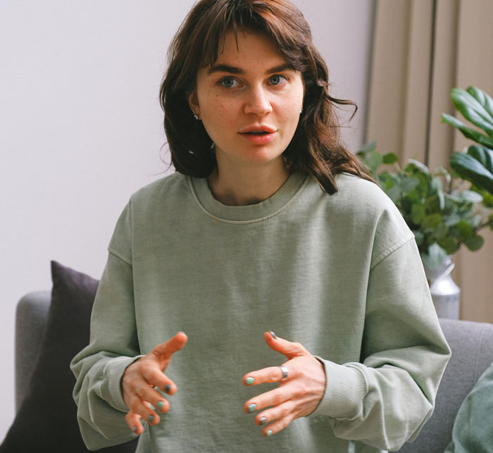 Woman expressing emotions while speaking, sitting on a couch on Mother's Day. Woman expressing emotions while speaking, sitting on a couch on Mother's Day.