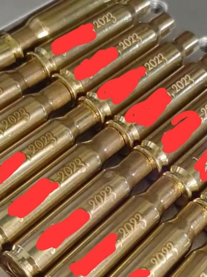 Wedding Favors Are Engraved Bullet Casings With The Date And The Couples' Names On Them
