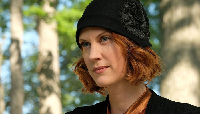 Woman with red hair in a black hat, gazing thoughtfully. Woman with red hair in a black hat, gazing thoughtfully.