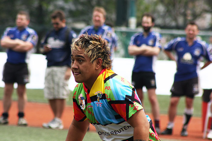 Rugby player with spiked hair preparing for play, highlighting a whale tail hairstyle trend popular with millennials.