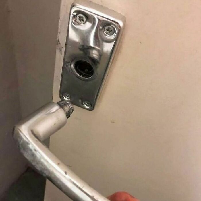 Broken door handle with detached lever revealing random and cringe humor in an everyday object photo.