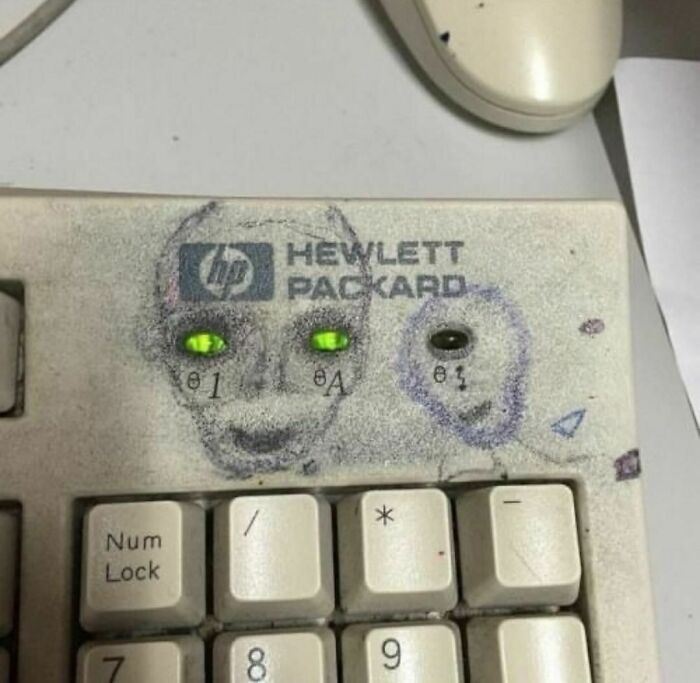 Old Hewlett Packard keyboard with LED lights and drawn faces, a random and cringe photo with unique humor.