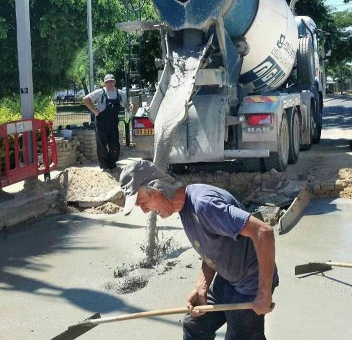 Construction worker humorously appearing to drink wet cement pouring from a mixer truck, showcasing random and cringe moments.