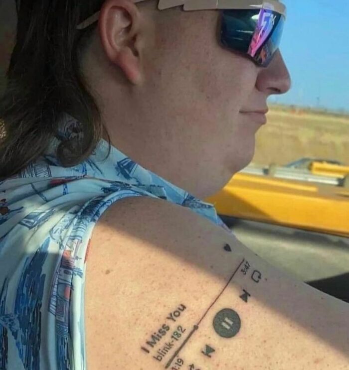 Man wearing sunglasses with a music player tattoo on arm featuring song I Miss You by Blink 182, random and cringe humor photo