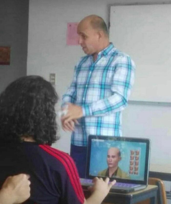 Person playing a random and cringe video game on a laptop while a man in a blue plaid shirt talks nearby.