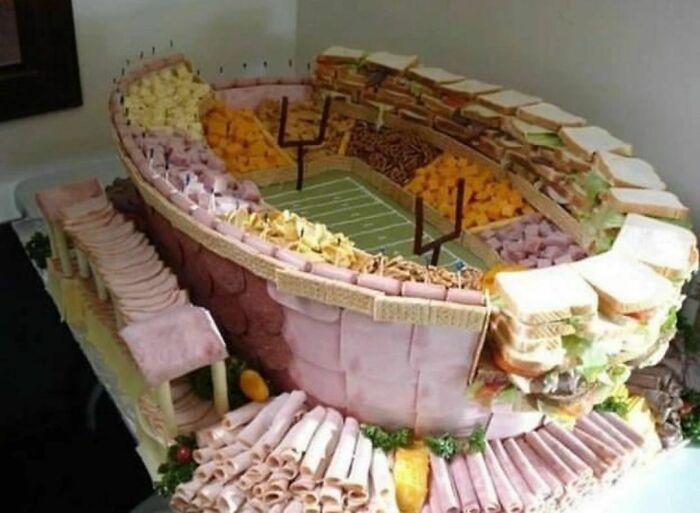 Snack stadium made of various deli meats and sandwiches, showcasing a random and cringe humor concept.