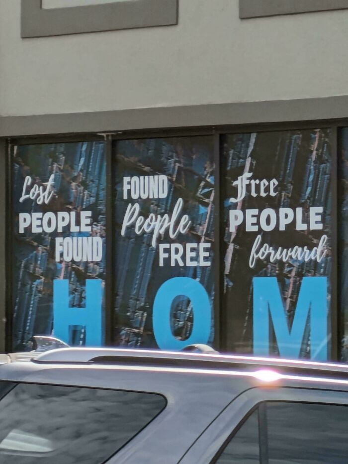 Sign fail with text: "Lost people found, found people free, free people forward" on window with car in front.