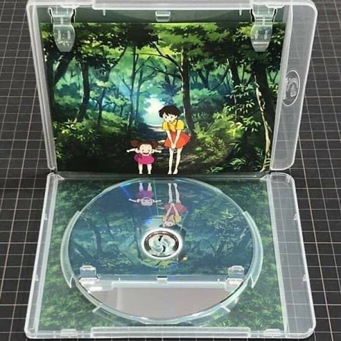Anime artwork of two girls in a forest reflecting perfectly on the empty disc inside a clear CD case for slight amusement and intrigue.