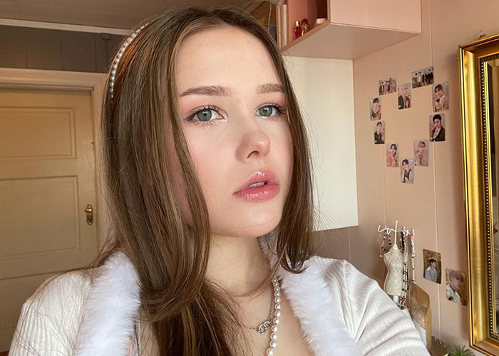 Young woman indoors, looking baffled, capturing the moment strangers start having a picnic in her yard. Young woman indoors, looking baffled, capturing the moment strangers start having a picnic in her yard.