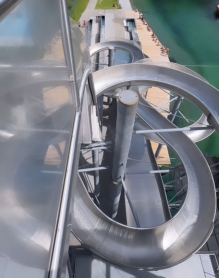 Extreme waterslide view from above, showcasing thrill-seeking diver's daring jump despite strict ban for women. Extreme waterslide view from above, showcasing thrill-seeking diver's daring jump despite strict ban for women.