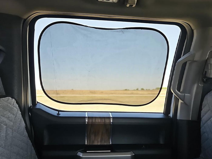 Car window sunshade installed in a vehicle interior.