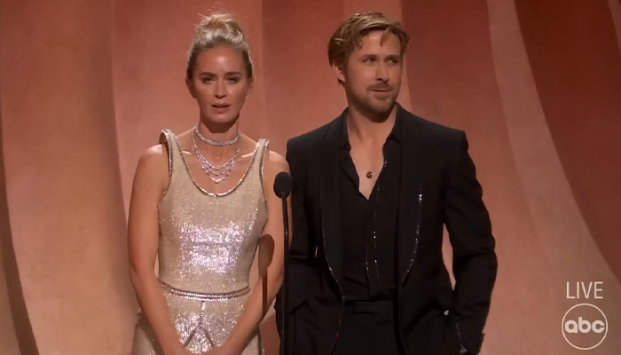 Man and woman on stage in formal attire, with man wearing a black suit, relevant to Ryan Gosling pictures. Man and woman on stage in formal attire, with man wearing a black suit, relevant to Ryan Gosling pictures.