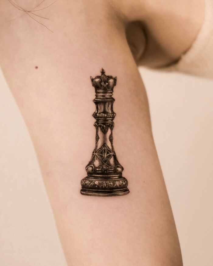 Hyperrealistic tattoo of a detailed chess piece on an inner arm. Hyperrealistic tattoo of a detailed chess piece on an inner arm.