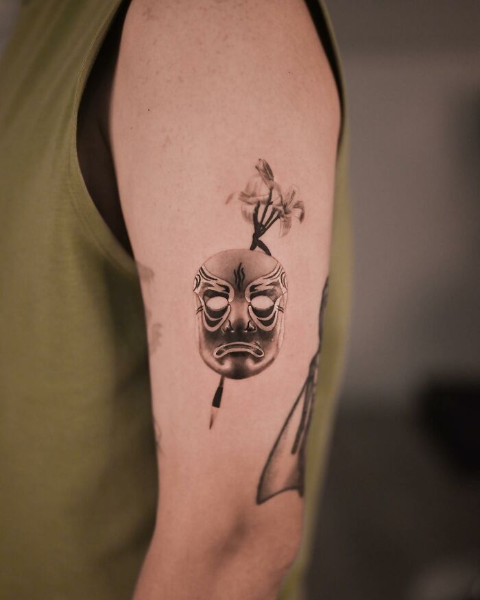 Hyperrealistic tattoo of a detailed mask on a person's arm. Hyperrealistic tattoo of a detailed mask on a person's arm.