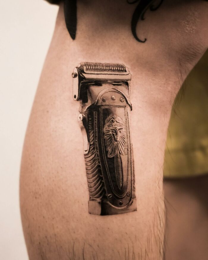 Hyperrealistic tattoo of a vintage hair clipper on a person's leg. Hyperrealistic tattoo of a vintage hair clipper on a person's leg.