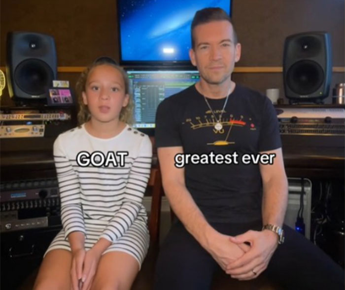 Father learning slang from daughter in a music studio, with text "GOAT" and "greatest ever" on screen. Father learning slang from daughter in a music studio, with text "GOAT" and "greatest ever" on screen.